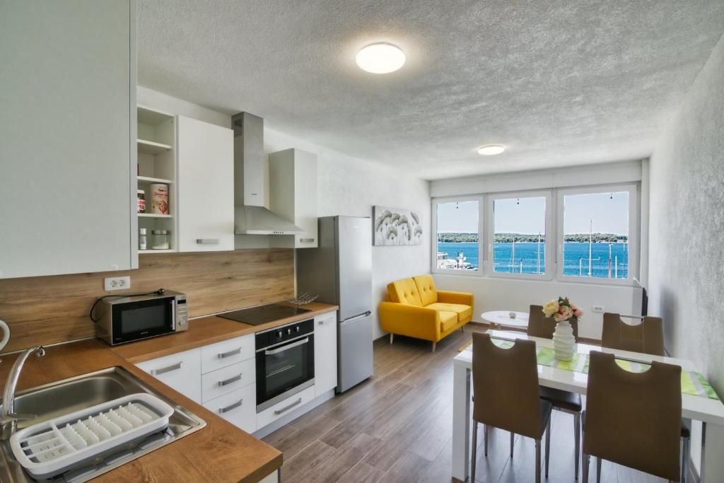 普拉Apartment Marina with sea view的厨房、带桌子的用餐室和用餐室