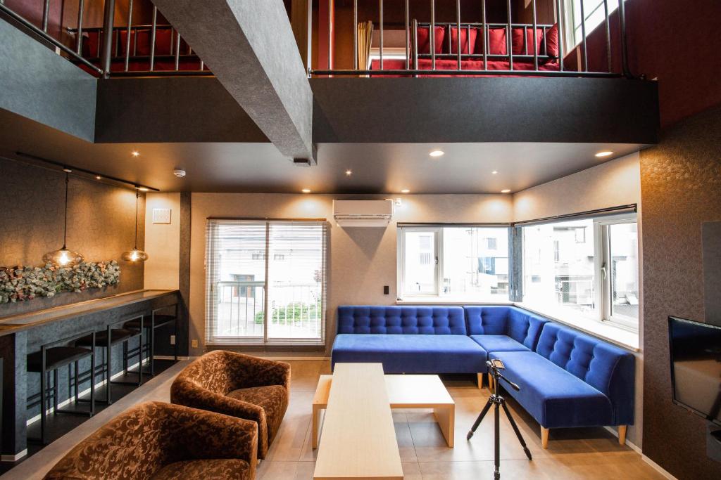 小樽THE BEEHIVE AIOI的客厅配有蓝色的沙发和椅子