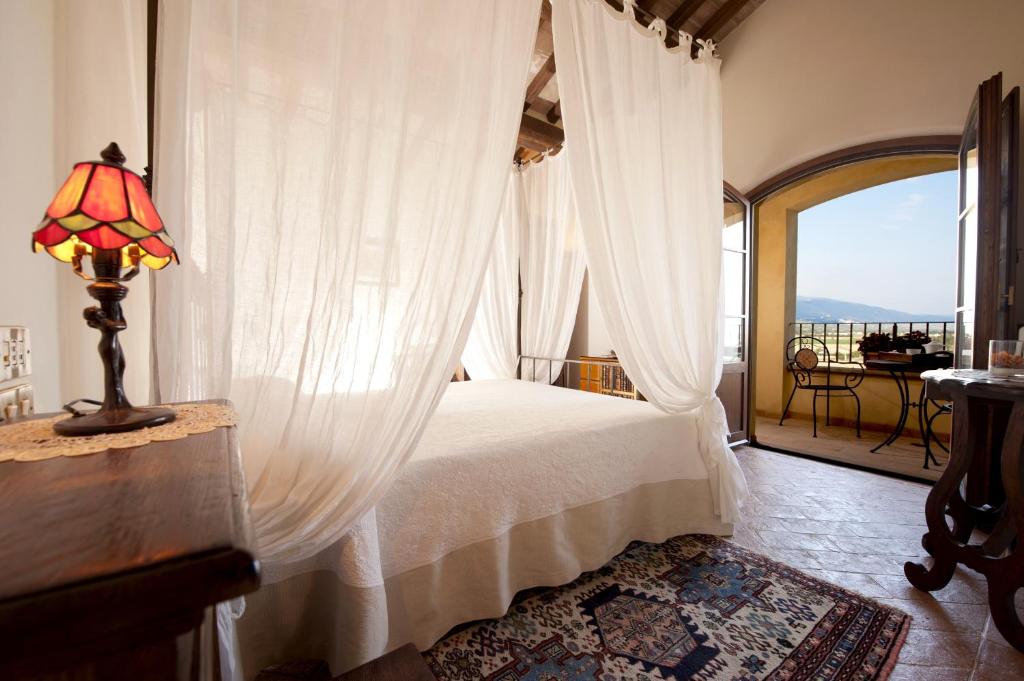 托奇亚基纳里帕里莱斯科尔德索尔酒店的一间卧室配有一张天蓬床和窗户