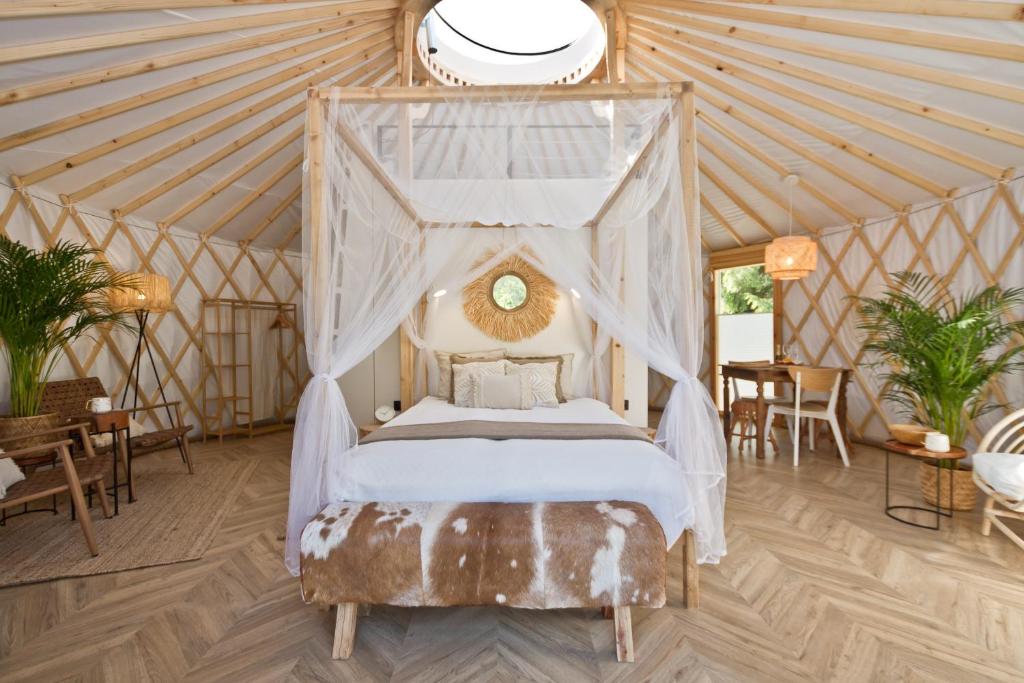 鲁比亚托沃JURTLANDIA jurta BOHO的蒙古包内一间卧室,配有一张天蓬床