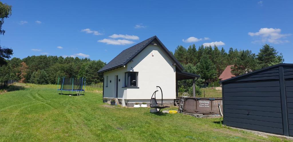 WierzchyWierzchy 34的一座白色的小房子,在田野上设有黑色屋顶