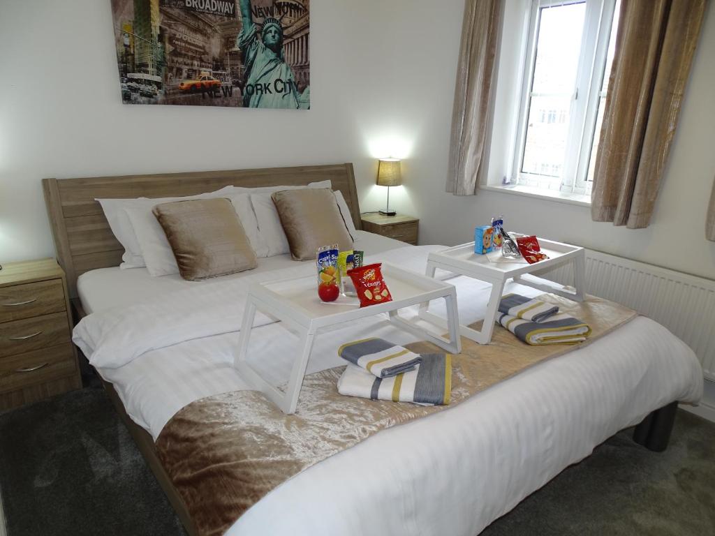 唐克斯特Ramskir Apartment的卧室配有一张带两张桌子的大型白色床