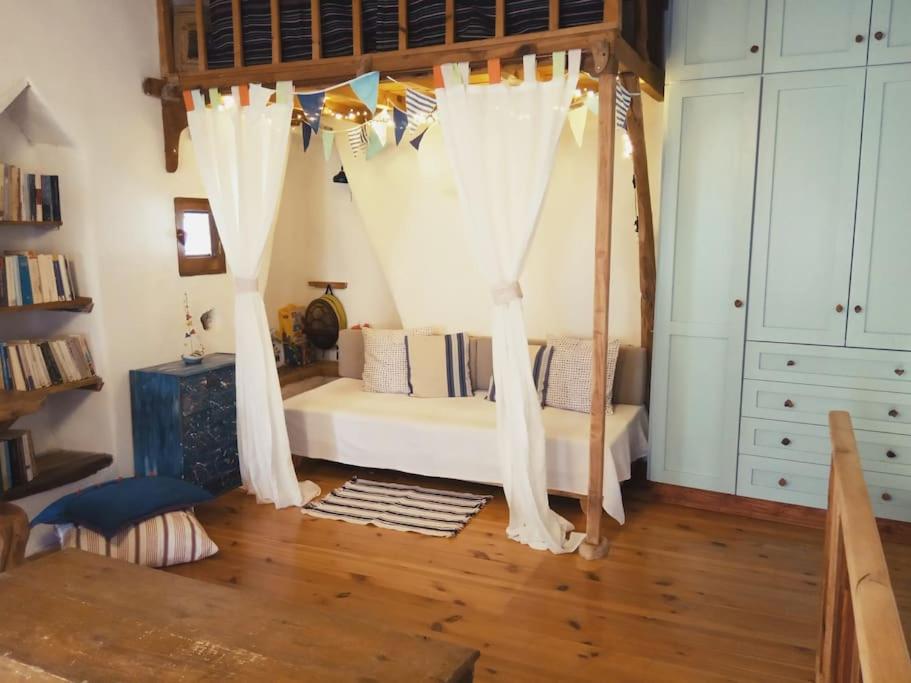 帕尔加Chaos Wooden Art House.的卧室配有带白色窗帘的天蓬床