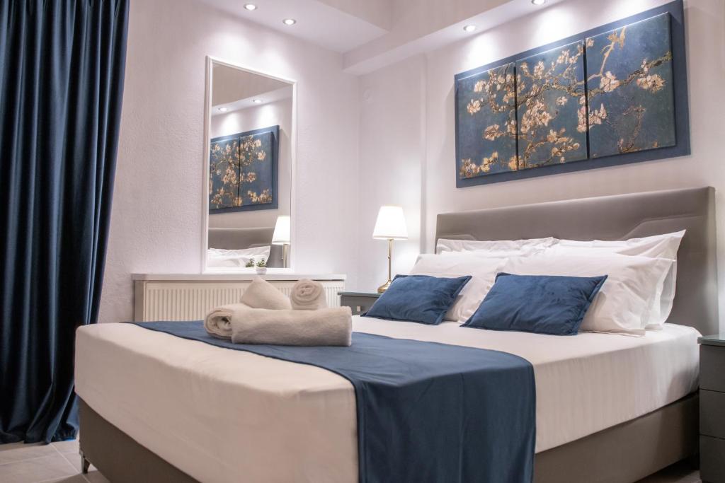 科莫蒂尼Mystique的一间卧室配有一张带蓝白色枕头的大床