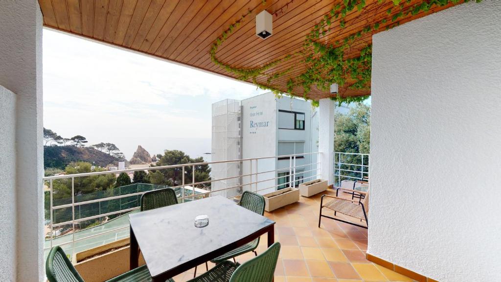 滨海托萨Villa Reymar - diseño y vistas al mar的大楼内的阳台配有桌椅