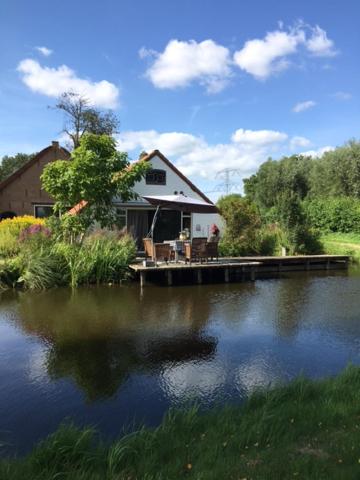 StolwijkDe Beijersche Stee , Landhuysje的湖中带码头的房子