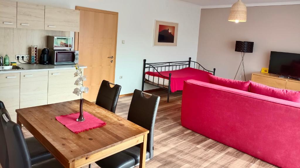 塔亚河畔拉镇Appartementhaus Thermeneck的客厅配有桌子和红色沙发