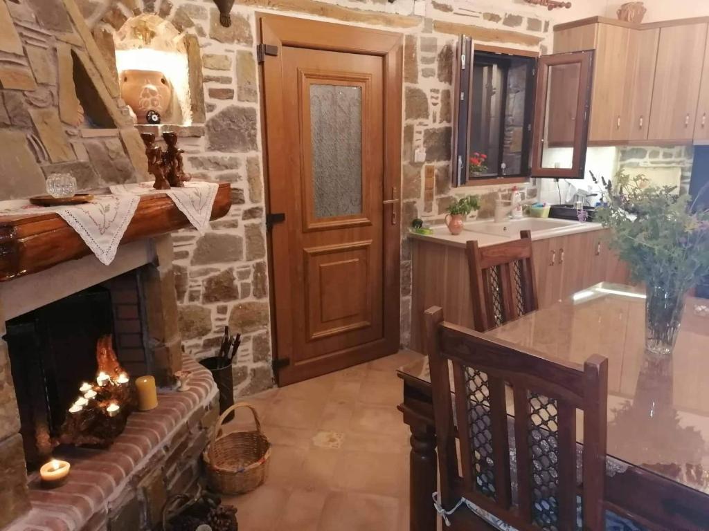 米里纳traditional house in Androni的一个带壁炉和木门的厨房