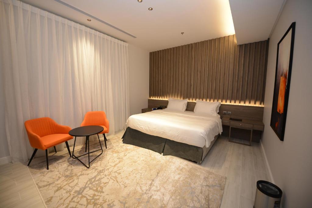 吉达WDF Serviecd Apartment的酒店客房带一张床、一张桌子和椅子