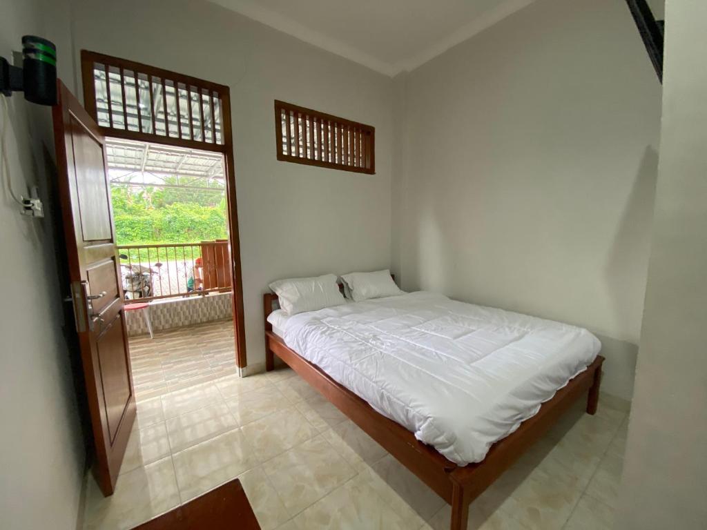 邦加槟港OYO 91419 Hotel Mulia Bangka的一间带床的卧室,位于带窗户的房间内