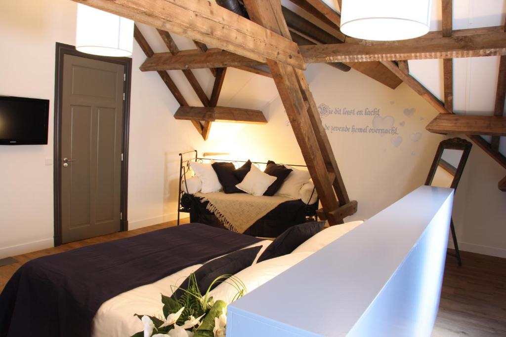 Aarle-Rixtel赫伯格布拉邦特克鲁斯酒店的一间带2张床的卧室,位于带木梁的房间