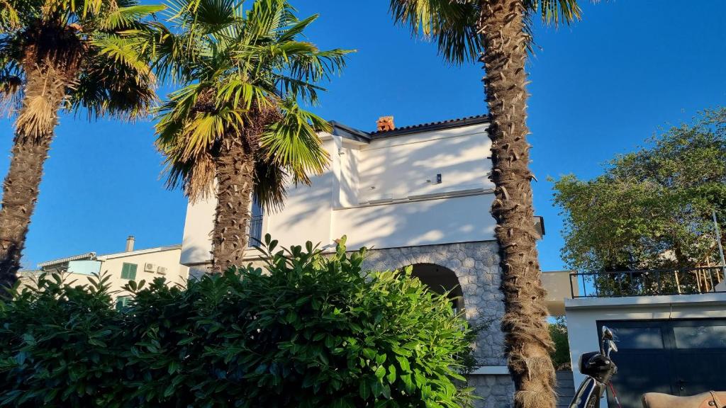 万塔西西Seaview Apartment Villa Sia的前面有棕榈树的房子