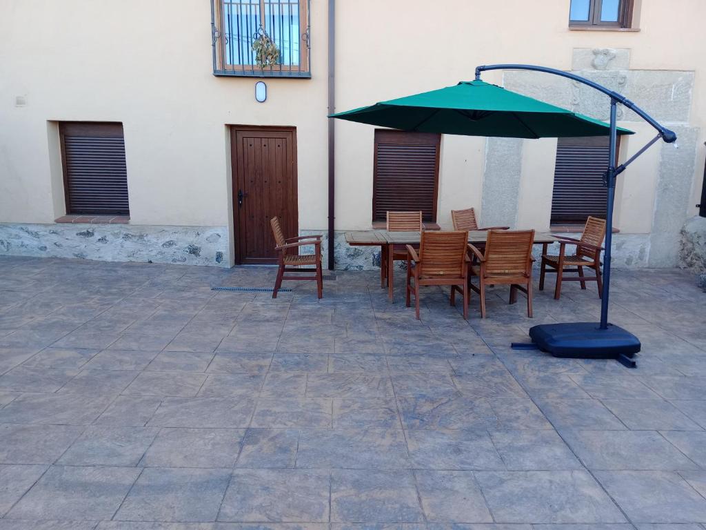 La LosaEl mirador de la sierra的庭院配有桌椅和遮阳伞。