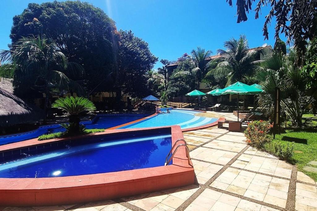 皮帕Solar de Pipa Prime Flat - Frente Piscina的一座树木繁茂的度假村内的大型游泳池