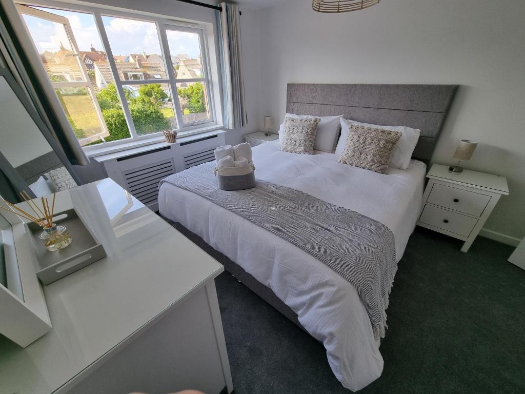 斯沃尼奇HighTide - 2 bed with parking, balcony & sea view.的一间卧室设有一张大床和两个窗户。