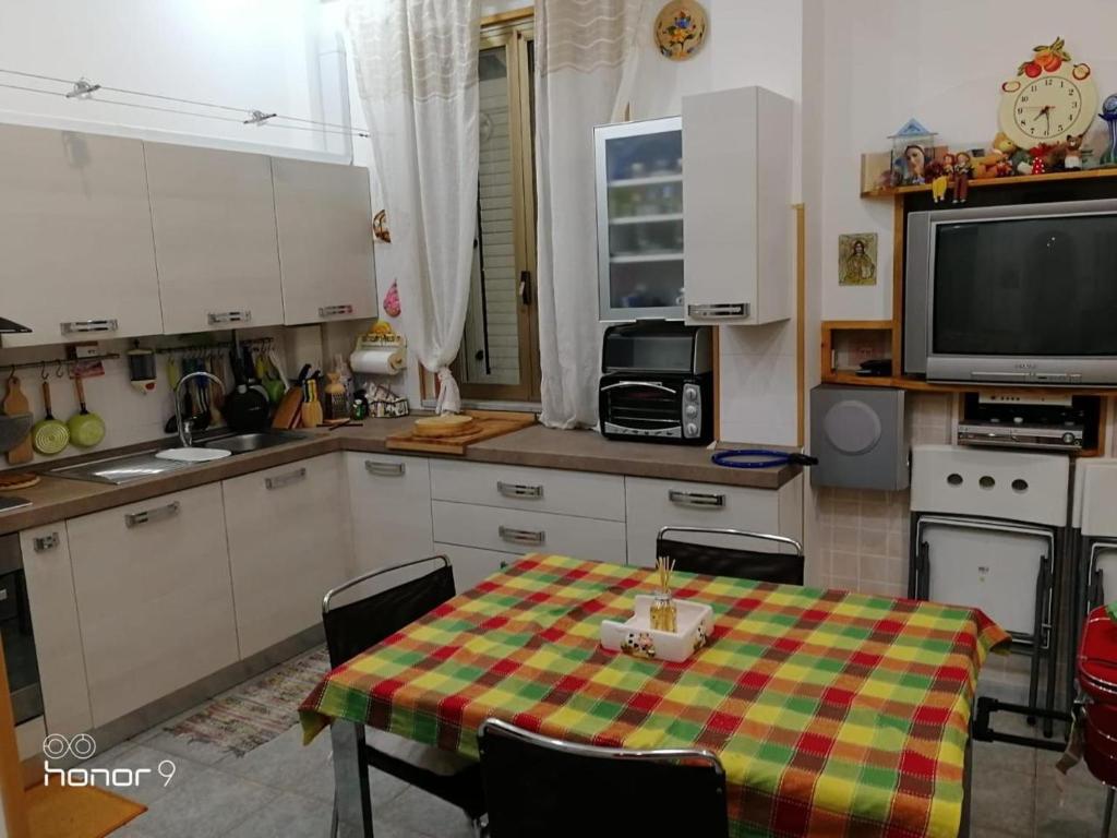 维博瓦伦蒂亚码头La Casetta Bianca Vicino Mare的厨房配有桌子和电视。