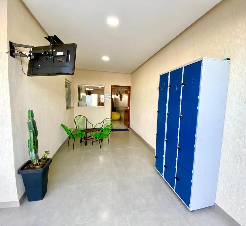 帕劳阿佩巴斯Hostel Flor de Carajás的走廊设有蓝色储物柜和桌椅