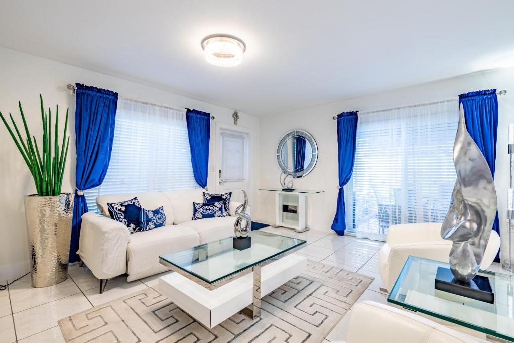 迈阿密Luxurious and cozy Townhouse 3 bedrooms 2.5 Bath的客厅配有蓝色窗帘和白色沙发