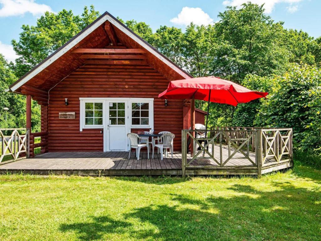 HovborgHoliday home Hovborg VII的小屋设有带桌子和遮阳伞的甲板