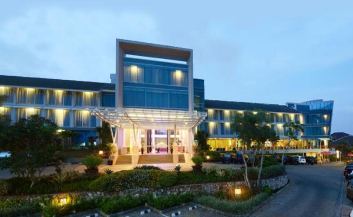 班达楠榜艾美西亚酒店和度假村的一座蓝色的大建筑,前面设有停车场