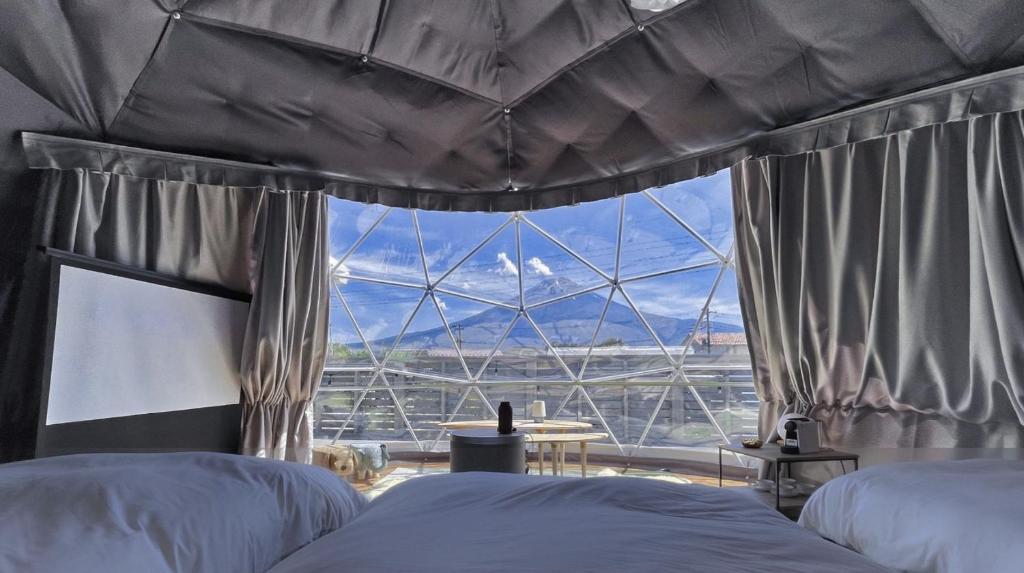 富士河口湖Necoana Glamping的一间卧室设有两张床和大窗户