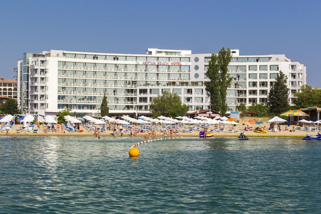 阳光海滩乐朋海滩酒店的一片带人与遮阳伞的海滩和一座大型建筑