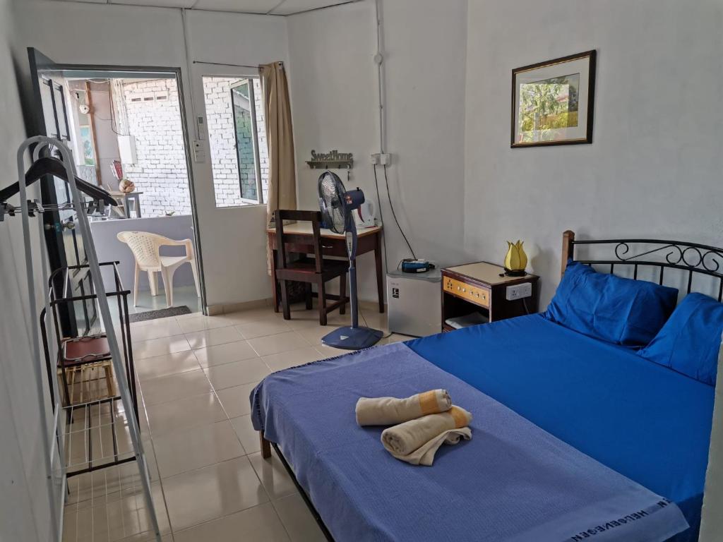 珍南海滩Langkawi Village Budget Rooms的一间卧室配有蓝色的床和蓝色的毯子