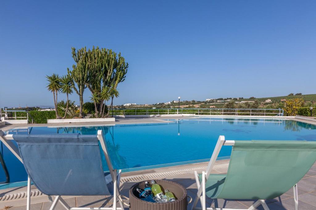 YiofirákiaSerenity Villa with pool, Kalesa Heraklion的一个带两把椅子的游泳池,棕榈树