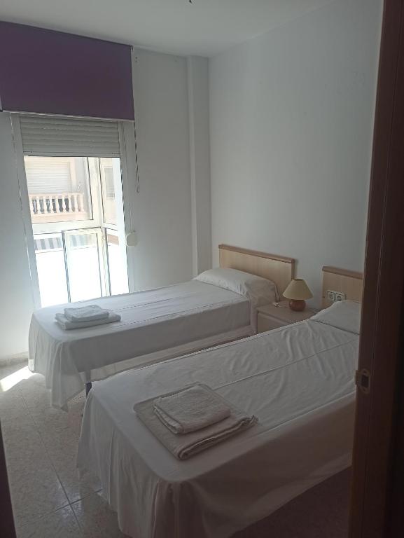拉梅特拉·德·玛尔La Rambleta的白色客房的两张床,设有窗户