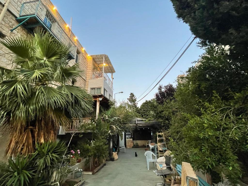 海法Diamond Apartment In Haifa的一座棕榈树建筑,毗邻一座建筑