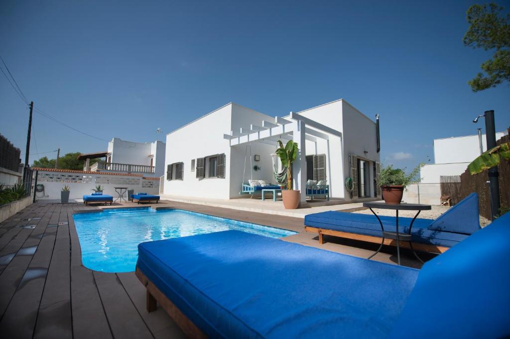 桑坦伊Ca n'Alorda Holiday Home Cala Llombards piscina, wifi, seguridad y relax的一个带2把蓝色椅子的游泳池