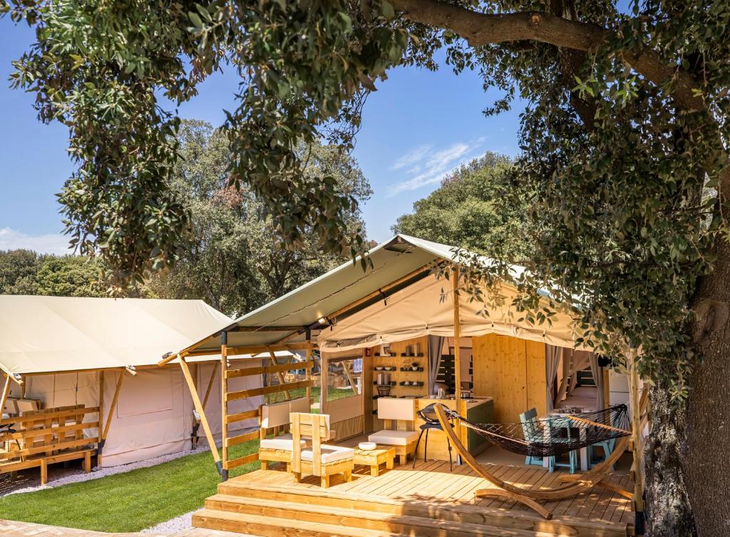 罗维尼Maistra Camping Amarin Glamping的一座带门廊和树的房子