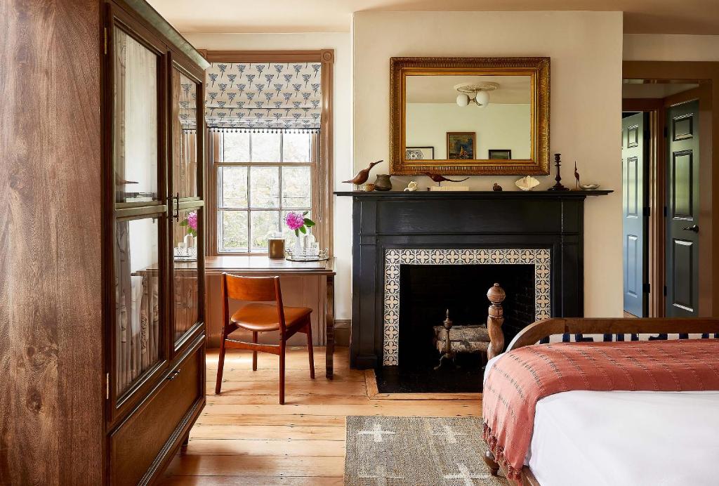 楠塔基特Blue Iris by Life House的一间卧室设有壁炉、镜子和一张床