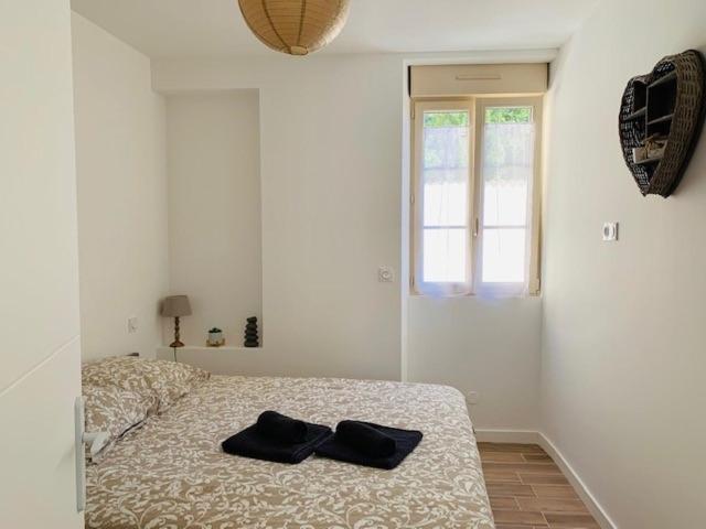 拉弗雷切Centre ville (1) : superbe appartement climatisé的一间卧室,床上有两双黑色鞋