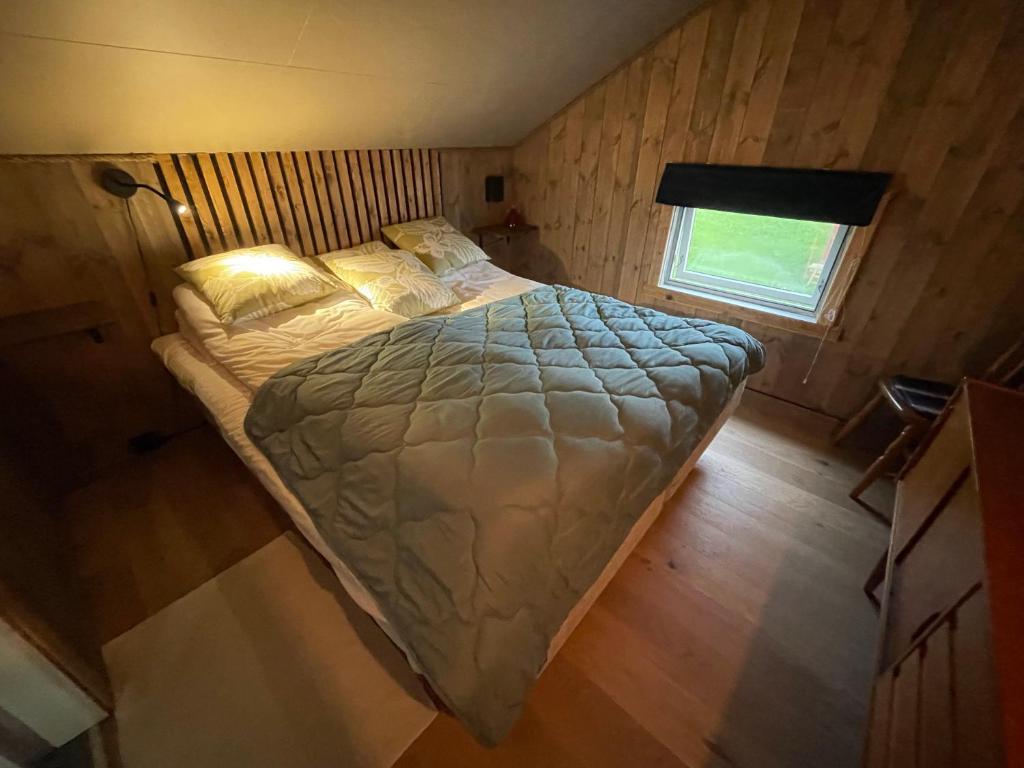 Rauvassgården, romslig, 5 sov, kjøkken, WiFi的一张位于小房间的大型床,设有窗户