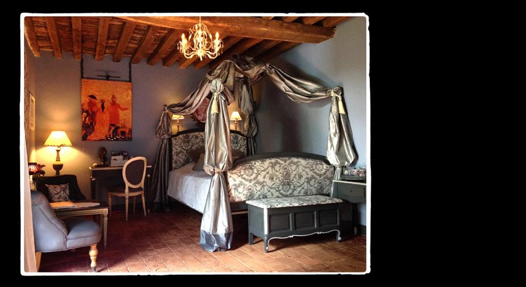 Saint-Germain-de-Livet利维庄园住宿加早餐旅馆 的一间卧室配有一张天蓬床和一把椅子
