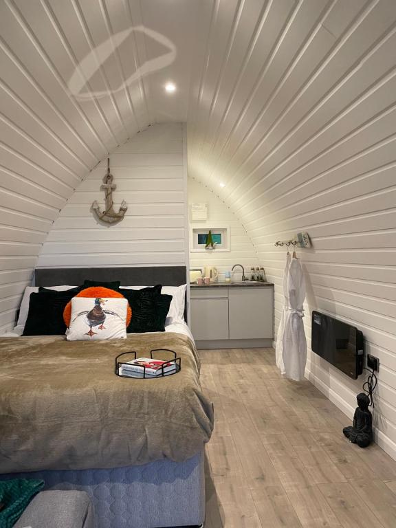 BurnfootPaddock Pod - Sleeps 4 & Roofed Over Private Hot Tub的一间带一张床铺的卧室,位于带天花板的房间内