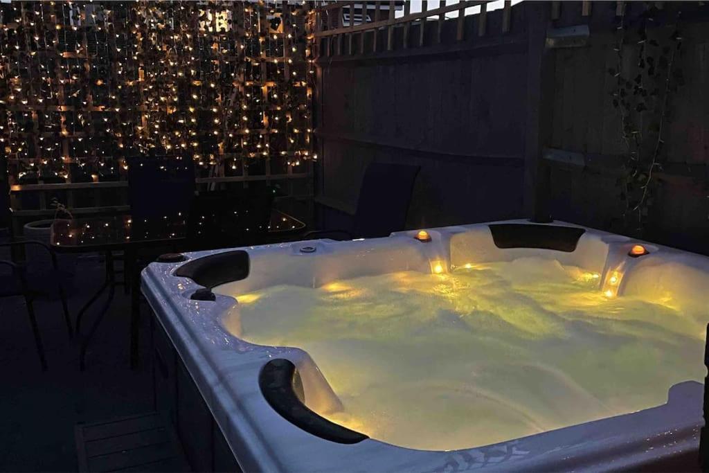 南安普敦Elmside, The Luxury New Forest Retreat的阳台的按摩浴缸(晚上)