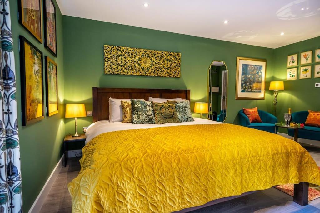 约克The Boutique York Garden Studio的一间卧室设有黄色的床和绿色的墙壁