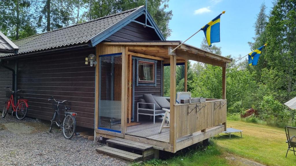 诺尔泰利耶Fritidshus Rostockvägen 40B - Guest House - Bring own bed sheets的小木屋设有甲板和自行车