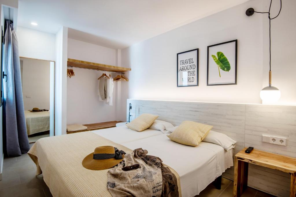 埃斯普霍斯Apartamentos Es Pujols - Emar Hotels的一间卧室,配有一张床,上面有帽子