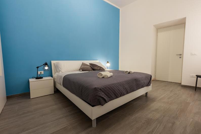 马尔萨拉Wine House Casa Vacanze的一间卧室设有一张蓝色墙壁的大床