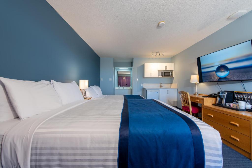 夸利库姆海滩海洋冠汽车旅馆 的一间带一张大床和一张书桌的卧室以及一间厨房