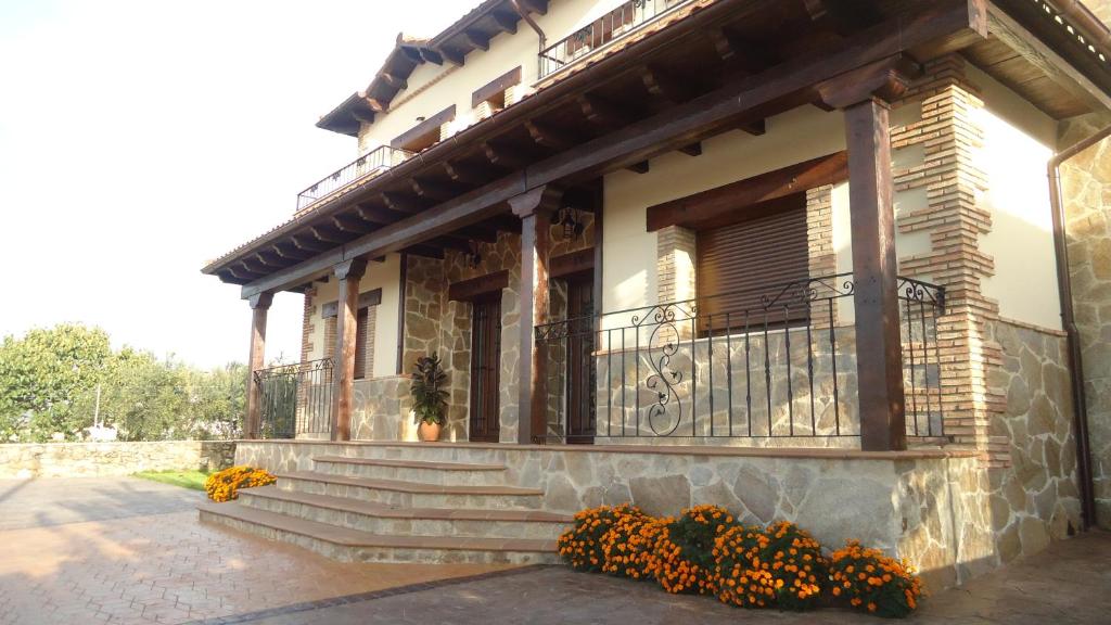 卡米诺新村Casas Rurales El Caminante的一座带楼梯的建筑和鲜花阳台