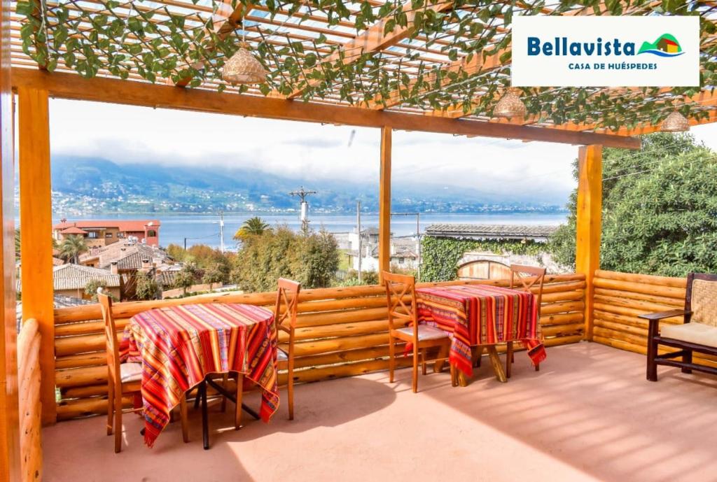 San PabloBellavista Casa de Huéspedes的甲板上配有两张桌子和椅子,享有水景