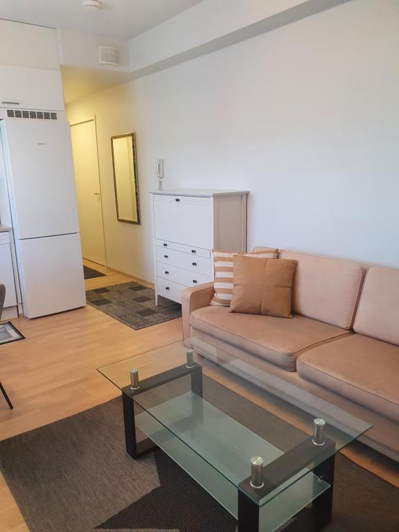 波里Moderni, viihtyisä pikkukaksio saunalla的带沙发和玻璃桌的客厅