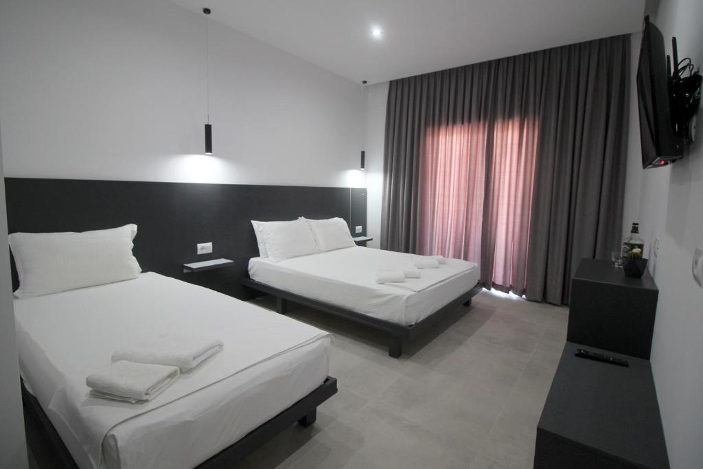 萨兰达Art De Jon Rooms的酒店客房设有两张床和电视。