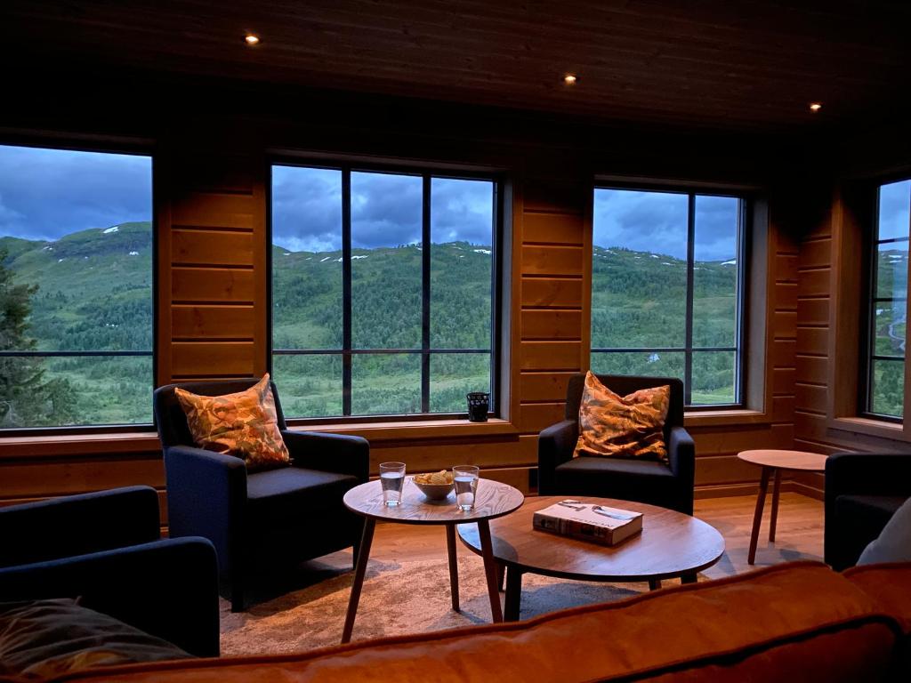 松达尔Hytte i Sogndal med panoramautsikt的客厅配有椅子和桌子,设有窗户