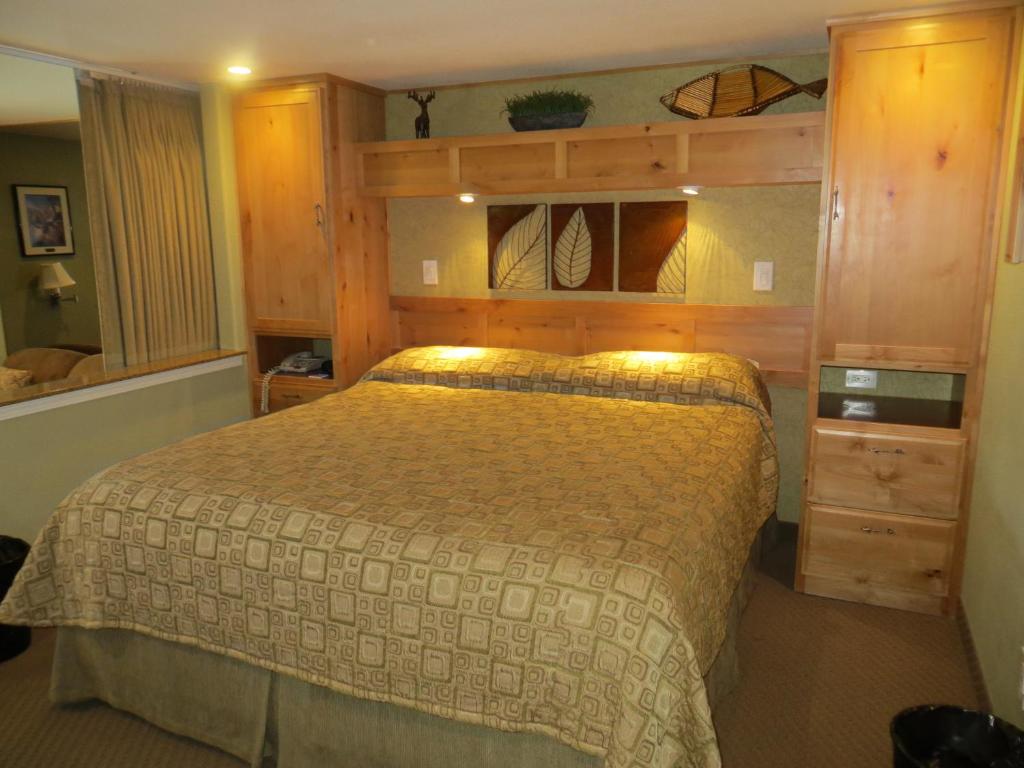 南太浩湖美洲村酒店的一间卧室配有一张床和木制橱柜