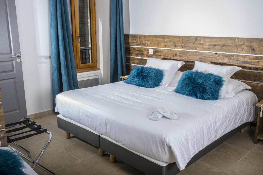 拉尔邦克La Tissandière的一间卧室配有一张带蓝色枕头的大床